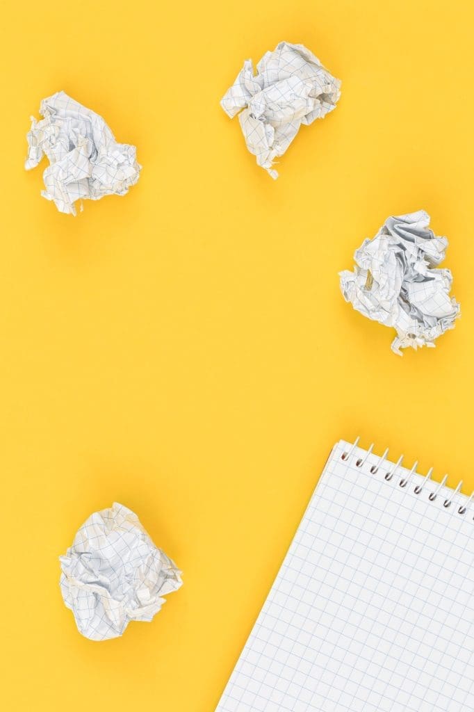 Empty notebook and crumpled paper balls, flat lay.